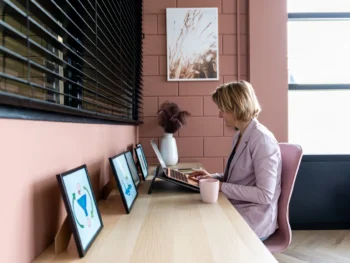 Portretfoto van Esther van Wageningen, specialist in loopbaanbegeleiding en stressfysiologie, achter haar bureau.