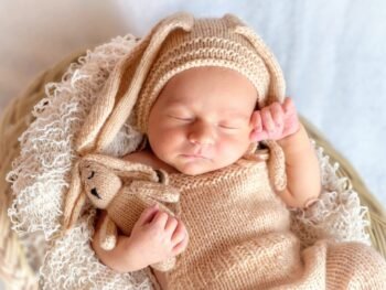Moeder met baby in de armen, worstelend met slaapgebrek en stress, illustrerend de ervaring van jonge ouders.
